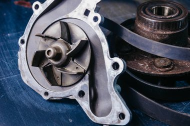 Mavi arkaplanda araba motoru soğutma sistemi için kullanılan su pompası.