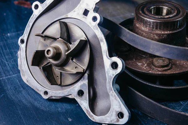 Mavi arkaplanda araba motoru soğutma sistemi için kullanılan su pompası.