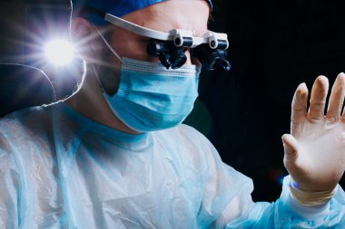 Nöroşirürji cerrahı bir klinikte yakın çekim lensli gözlüklerle ameliyat yapıyor..