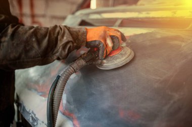 Bir araba öğütüyor, bir cesedi boyaya hazırlıyor, araba tamirine..