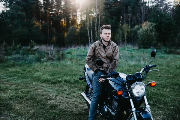 革の茶色のジャケットの男と夏の森のオートバイ街のオートバイ オートバイ愛好家のバイカー — ストック写真