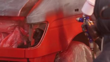 car painting in the garage, red paint.