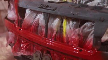 car painting in the garage, red paint.