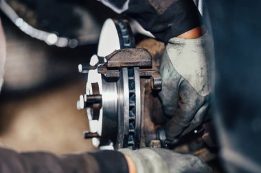 installation of a new brake disc in a car, repair of a brake system in a car service.