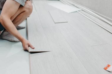 Döşeme kaplamalarında çalışan genç bir kadın.