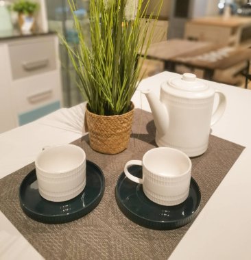 Beyaz masada çay seti ve rattan vazo ile kompozisyon. Arkadaşlarla ya da akrabalarla çay partisi hazırlığı. Öğleden sonra çay saati..