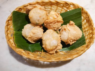 Dokuma sepetinde altın renkli kızarmış tofu. Tapyoka nişastası ve Endonezya aperatifi ile doldurulmuş kızarmış tofu walik. Üst görünüm.