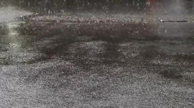 Gece bir şehir caddesinde sağanak yağmurun şiddetini hissedin. Yağmurun asfalta düşüşünü izleyin. Su birikintileri ve yansımalar yaratın. Arabalar geçerken, dinamik bir element ekleyin..