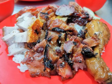 Gevrek kızarmış domuz eti, ızgara domuz eti ve pofuduk pirinçli lezzetli tavuğun servis edildiği ağız sulandırıcı bir tabak. Bu yemek zevki doyurucu bir öğle ya da akşam yemeği için mükemmel..