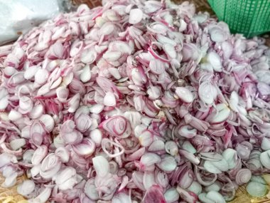 Taze ürünleri ve yemek malzemelerini temsil eden kabuklu arpacık soğanlarını market tezgahında üst üste dizin