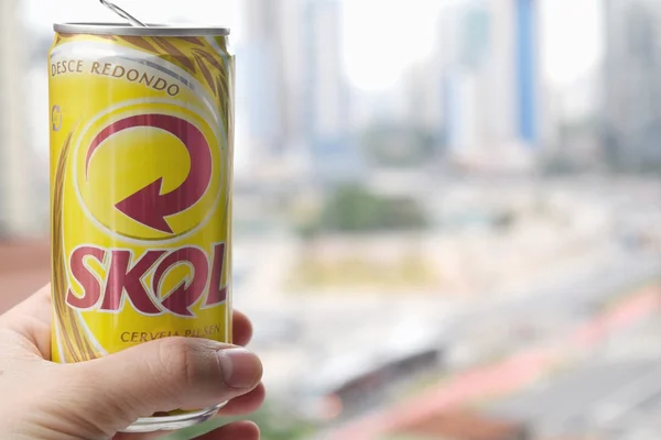 Mão segurando Skol cerveja pode — Fotografia de Stock