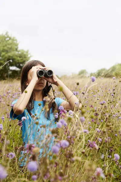 Girl holding binoculars — Stock Photo, Image