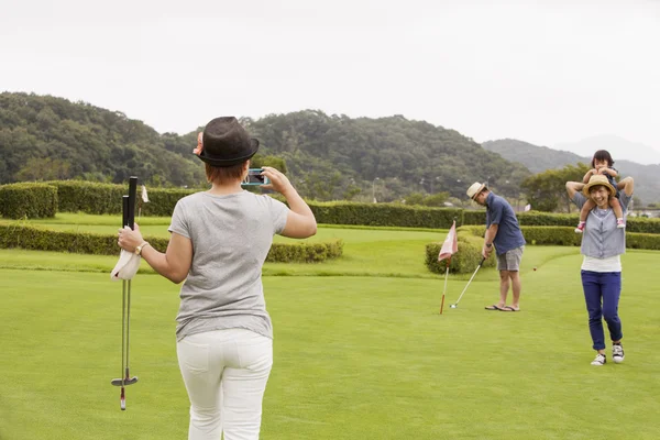 Japanse familie op een golfbaan. — Stockfoto