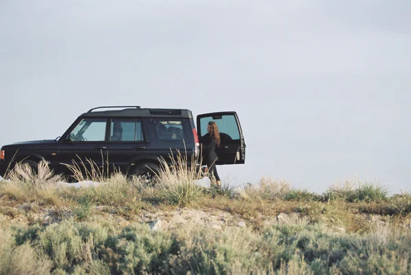 Woman standing by jeep — Stock Photo, Image