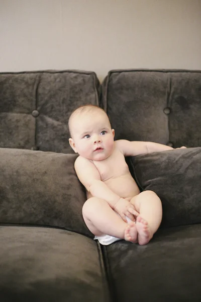 Bayi duduk disangga di sofa — Stok Foto