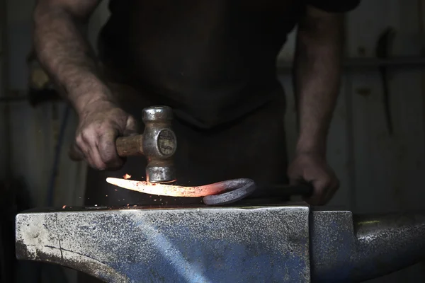 Blacksmith shaping a hot piece of iron — Stock Photo, Image