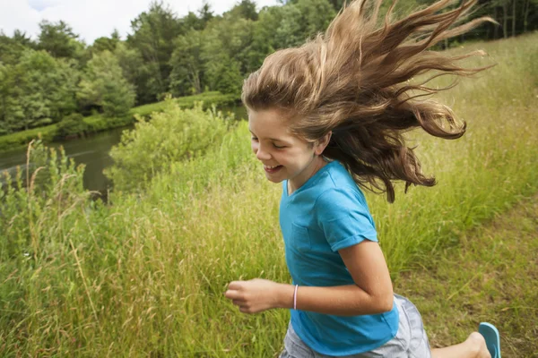 Girl running along a path by a lake — Stock Photo, Image