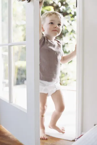 Ung pojke öppna en dörr. — Stockfoto