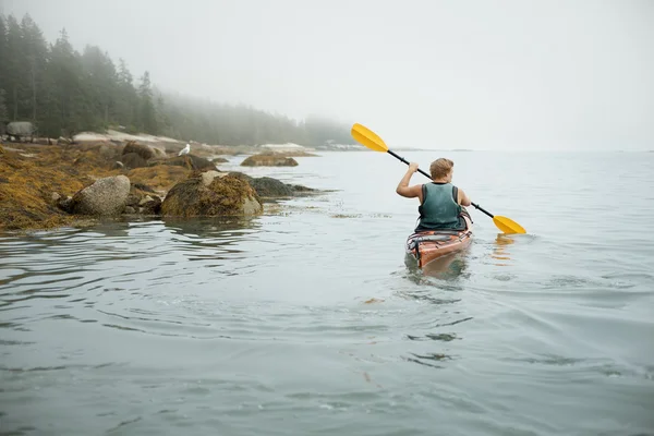 Man paddling a kayak on calm water — Stock Photo, Image