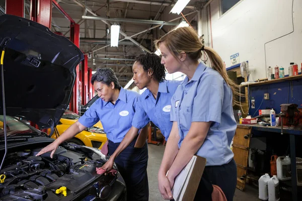 Drei Mechanikerinnen Unterhalten Sich Beim Blick Den Motorraum Eines Autos — Stockfoto