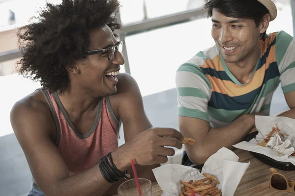 Hombres sentados comiendo en un restaurante . - foto de stock