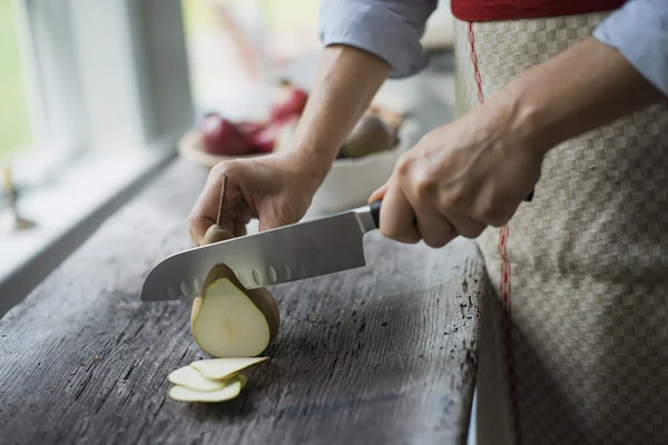Woman slicing a fresh picked fruit — Stock Photo