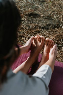 Yoga pratiği yapan bir kişi bir minderin üzerinde, ileri doğru uzanıyor, ayaklarına doğru uzanıyor. Görüntü, yoga yoluyla rahatlama ve esnekliğe odaklanan huzurlu bir ortam yakalıyor..