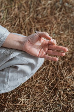 Meditasyon pozunda el dinlenmesi, parmaklar doğal zemin üzerinde bir mudra oluşturur, açık hava meditasyonu sırasında dinginliği ve farkındalığı sembolize eder.