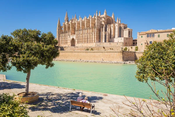 Coppia anziana che si riposa al parco vicino alla cattedrale principale di — Foto Stock