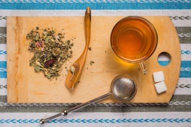 Bir fincan çay bir yığın kuru otlar ile üstten görünüm ahşap bir masa üzerine