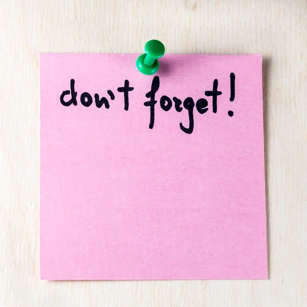 Don't forget note on paper post it pinned to a wooden board