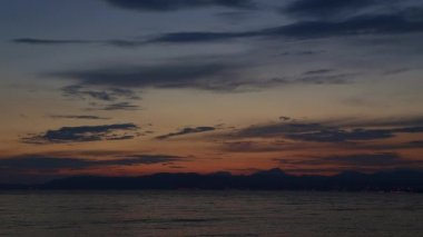 Deniz ve dağlar üzerinde günbatımında kalktıktan uçak