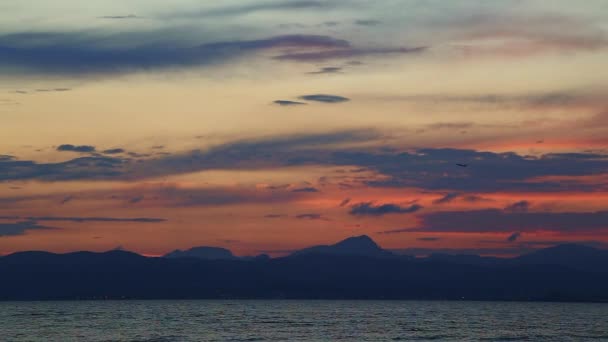 Décollage de l'avion au coucher du soleil au-dessus de la mer et des montagnes — Video