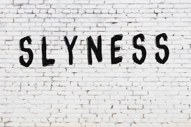 Beyaz tuğla duvara kazınmış bir yazı.