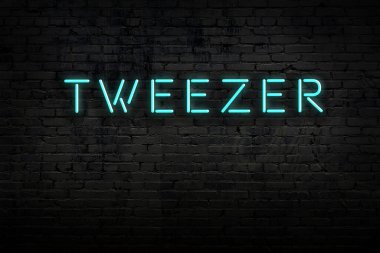 Tuğla duvardaki neon levhanın gece görüşü ve yazıt cımbızı