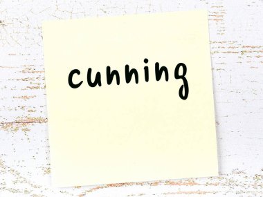 Tahta duvardaki sarı yapışkan notta el yazısıyla yazılmış kurnazlık var.