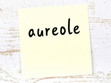 Tahta duvarda el yazısı Aureole olan sarı yapışkan bir not.