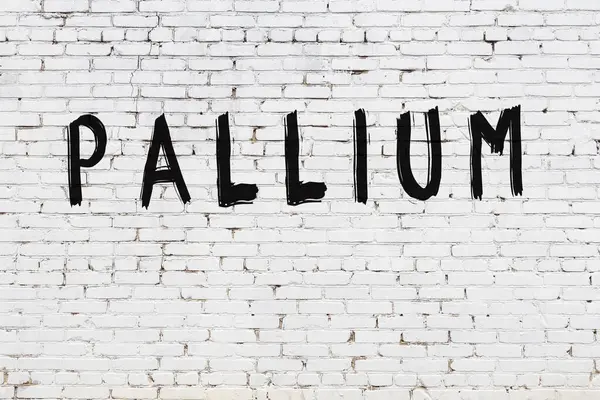 Napis pallium malowany na ścianie z białej cegły — Zdjęcie stockowe
