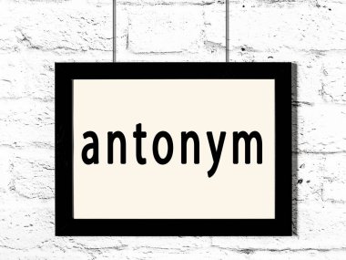 Beyaz tuğla duvarda asılı duran siyah çerçeve.