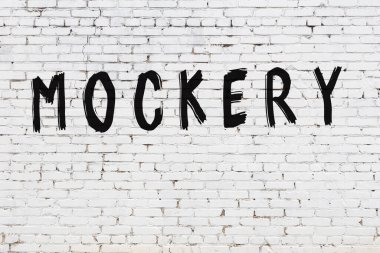 Beyaz tuğla duvara yazılmış yazıt alay konusu.