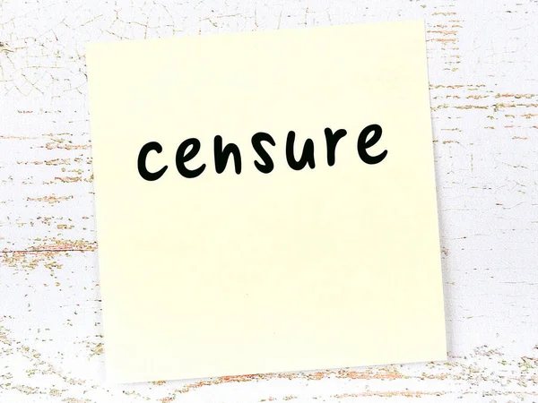 Yellow sticky note on wooden wall with handwritten word censure — Stock Photo, Image