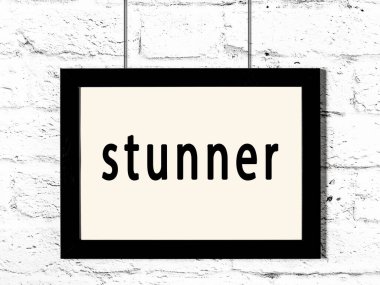 Beyaz tuğla duvarda asılı siyah çerçeve ve yazıt sersemletici.