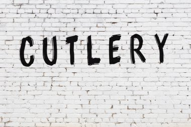 Üzerinde siyah boya ve çatal bıçak olan beyaz duvar.