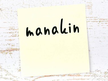 Tahta duvarda el yazısıyla yazılmış sarı yapışkan bir not var.