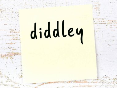 Tahta duvarda el yazısıyla yazılmış sarı yapışkan bir not var.