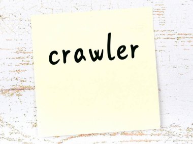 Tahta duvarda el yazısıyla yazılmış sarı yapışkan bir not var.