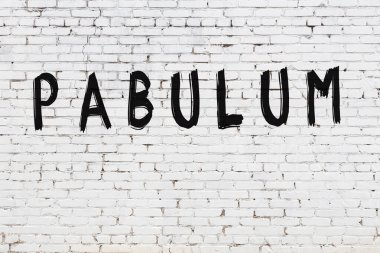 Üzerinde siyah boya yazılı pabulum olan beyaz duvar.