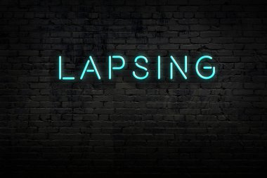 Tuğla duvardaki neon levhanın gece görüşü ve yazı süresi doluyor.