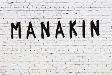 Beyaz tuğla duvara manakin yazılmış.