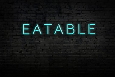 Neon işareti. Kelime tuğla duvara karşı yenebilir. Gece görünümü
